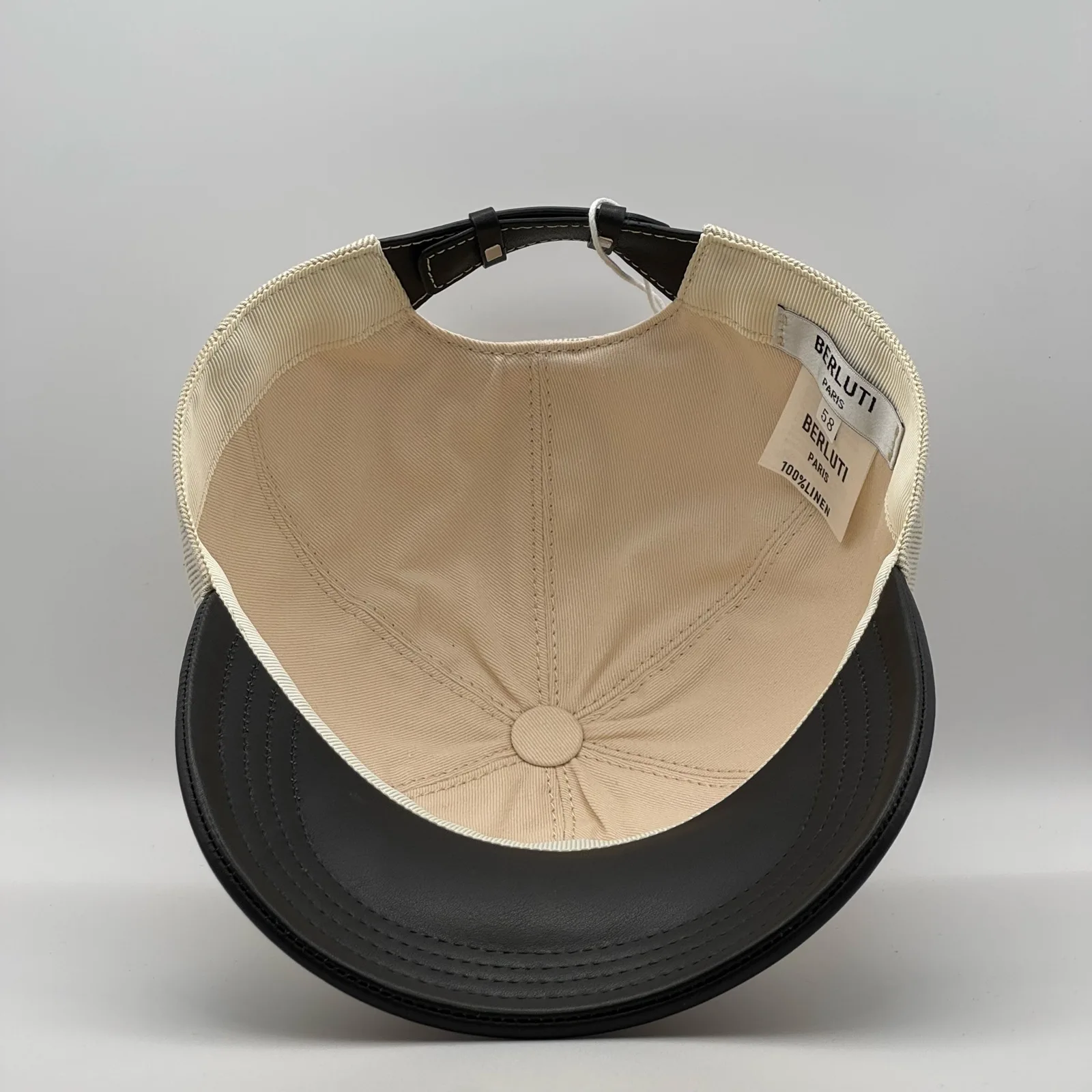 Berluti linen cap, underside view showing the cream interior lining and black brim.