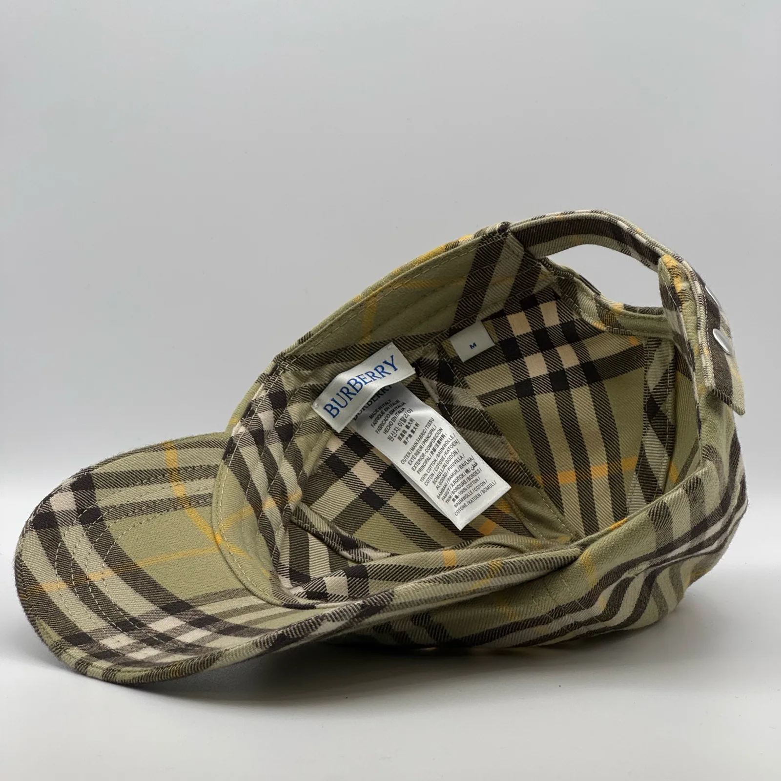 Close-up of the interior tag inside the olive check cap.