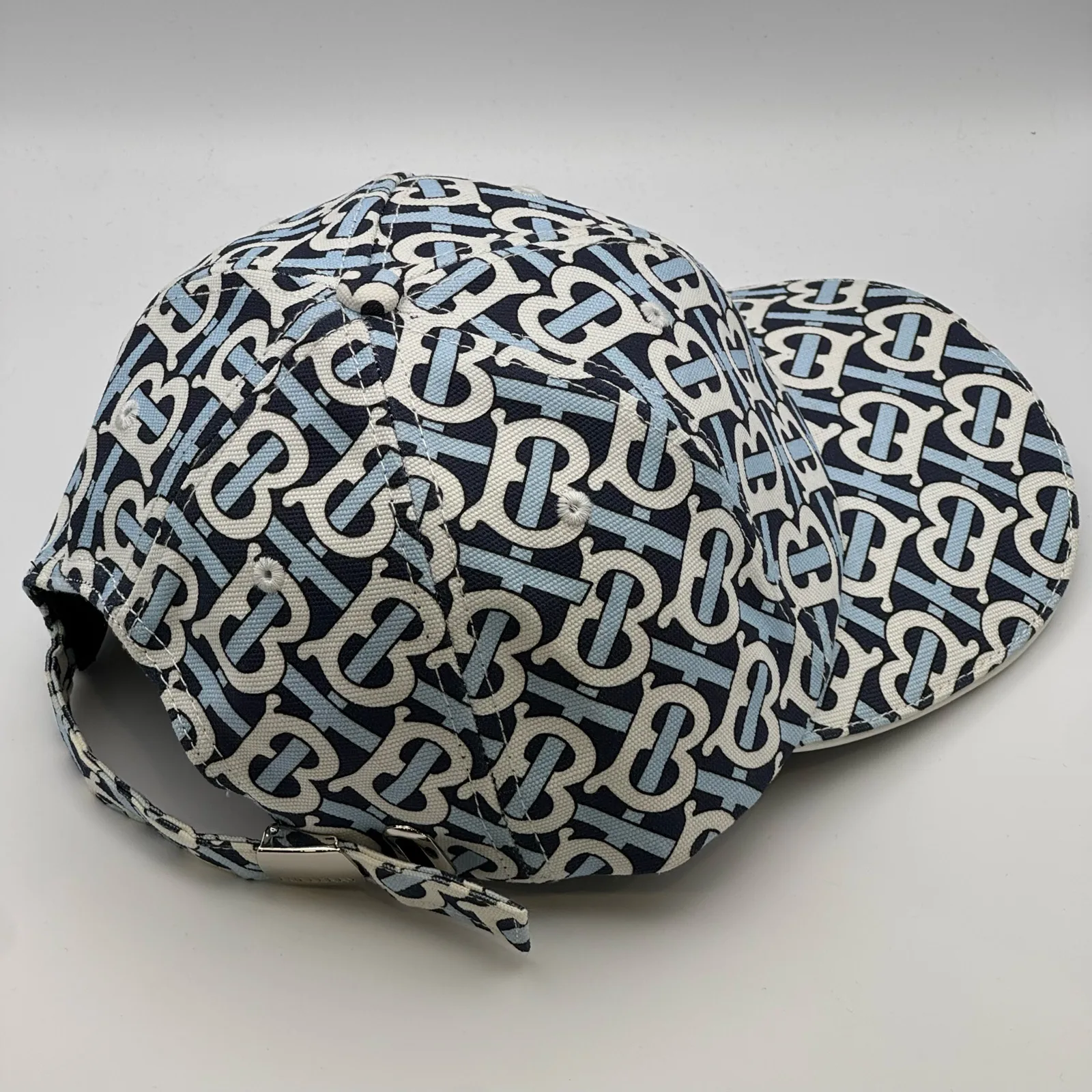 Navy Burberry TB Monogram cap, elevated three-quarter view of the crown and brim.
