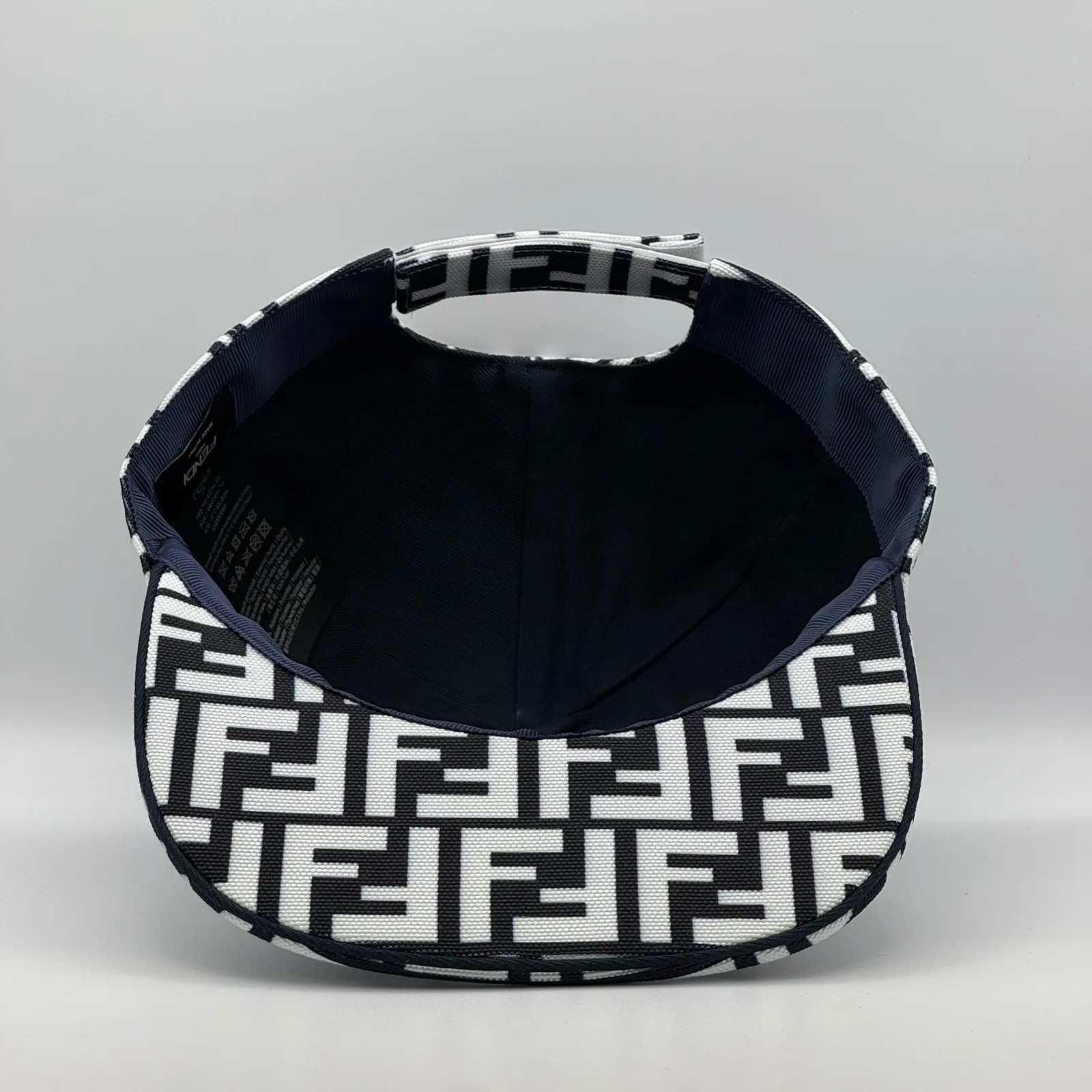 Underside of the black and white FF cap, brim lifted to show the navy interior.
