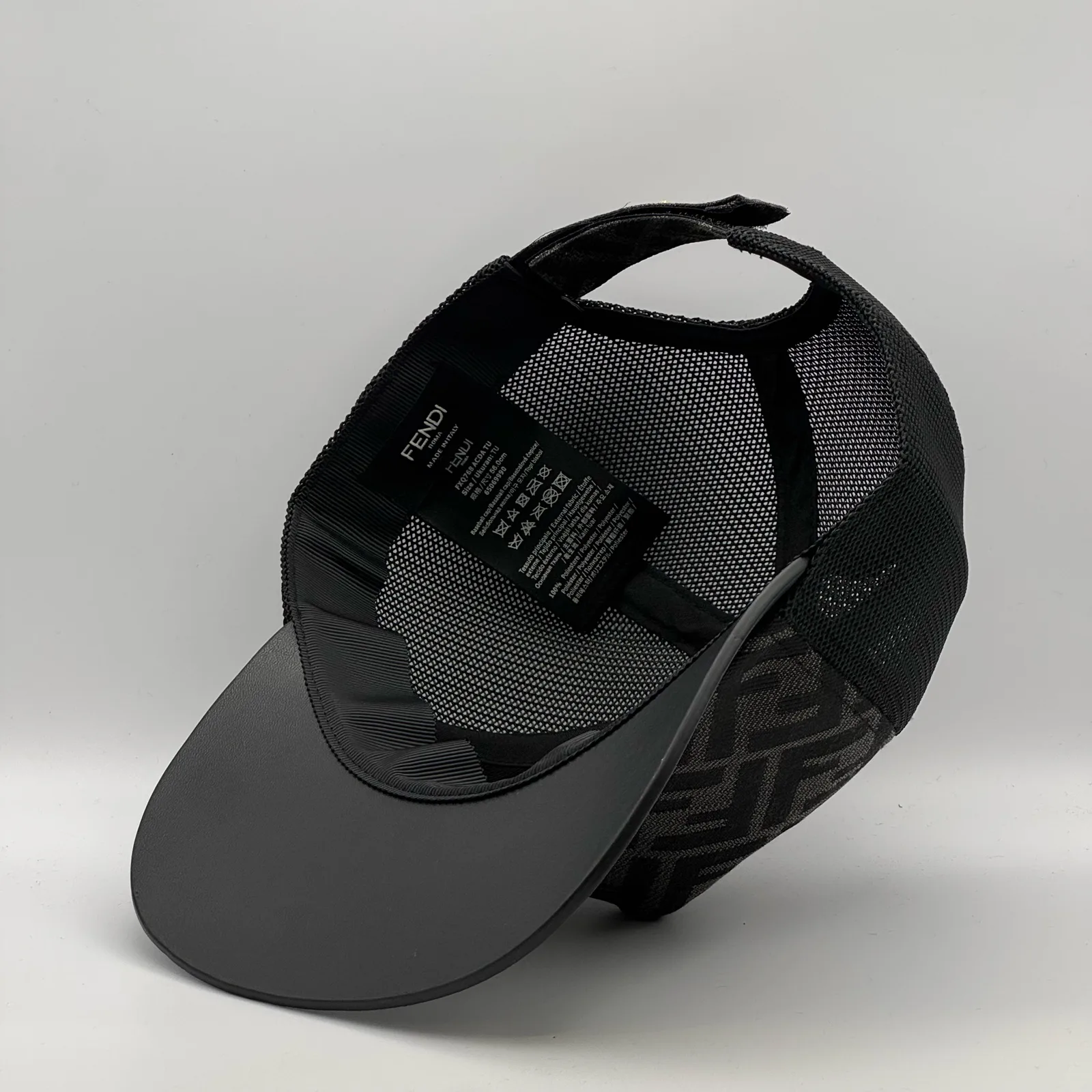 Underside of the black FF trucker cap, brim lifted to show the interior and tag.