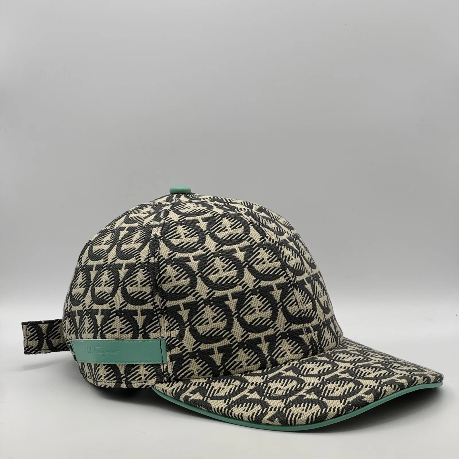 Ferragamo Gancini cap, three-quarter view showing the strap tab at the side.
