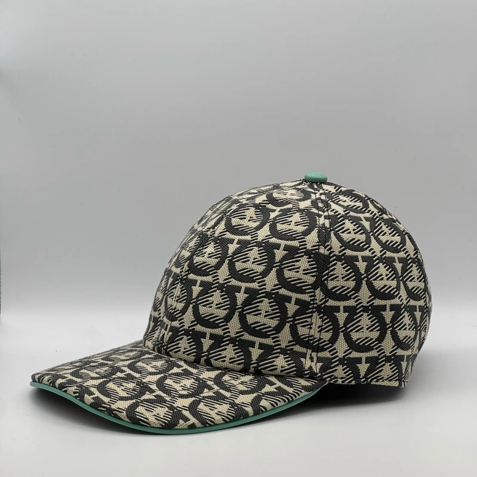 Ferragamo Gancini cap, side profile in the woven Gancini print with mint trim.