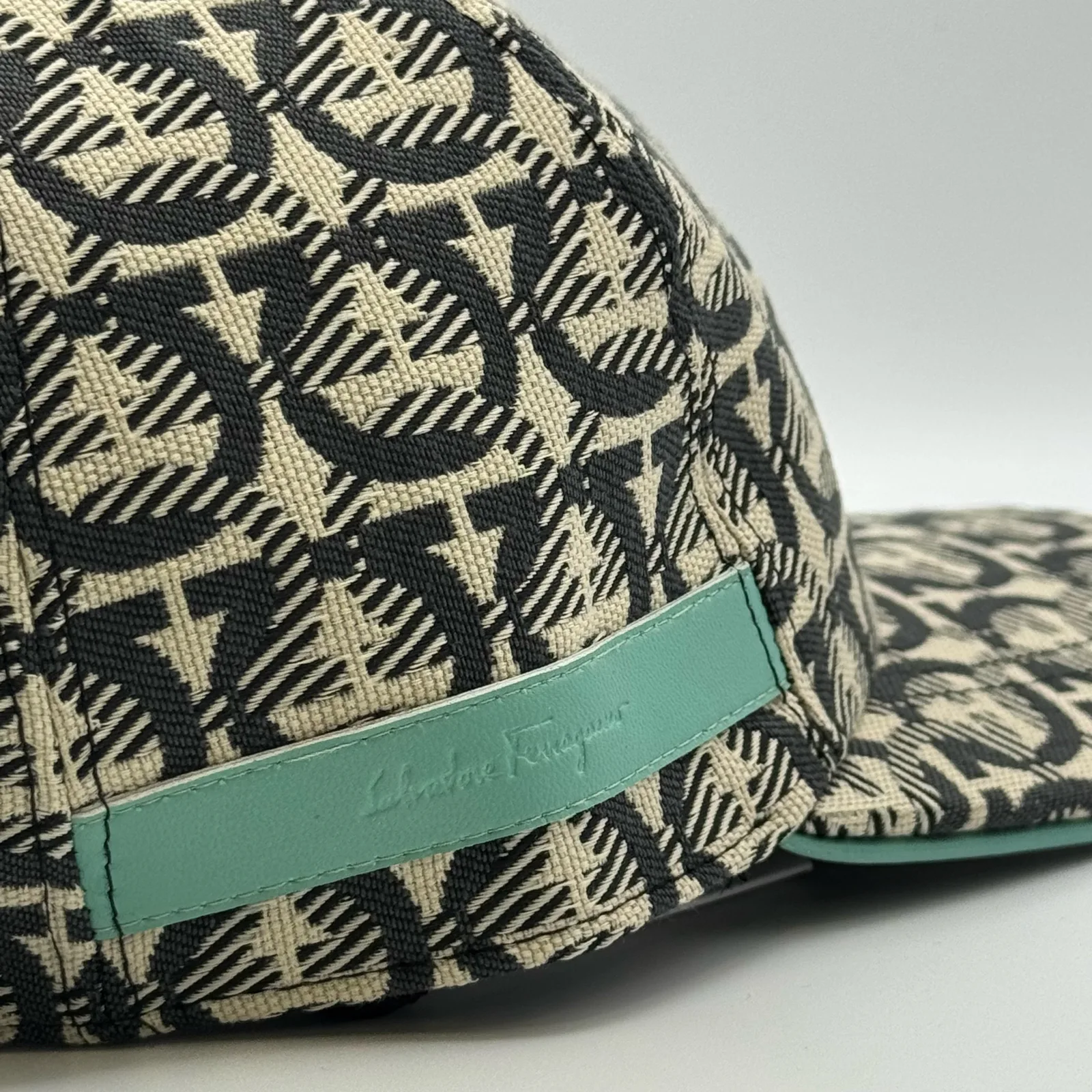 Close-up of the mint green edge trim and woven brand label near the brim.