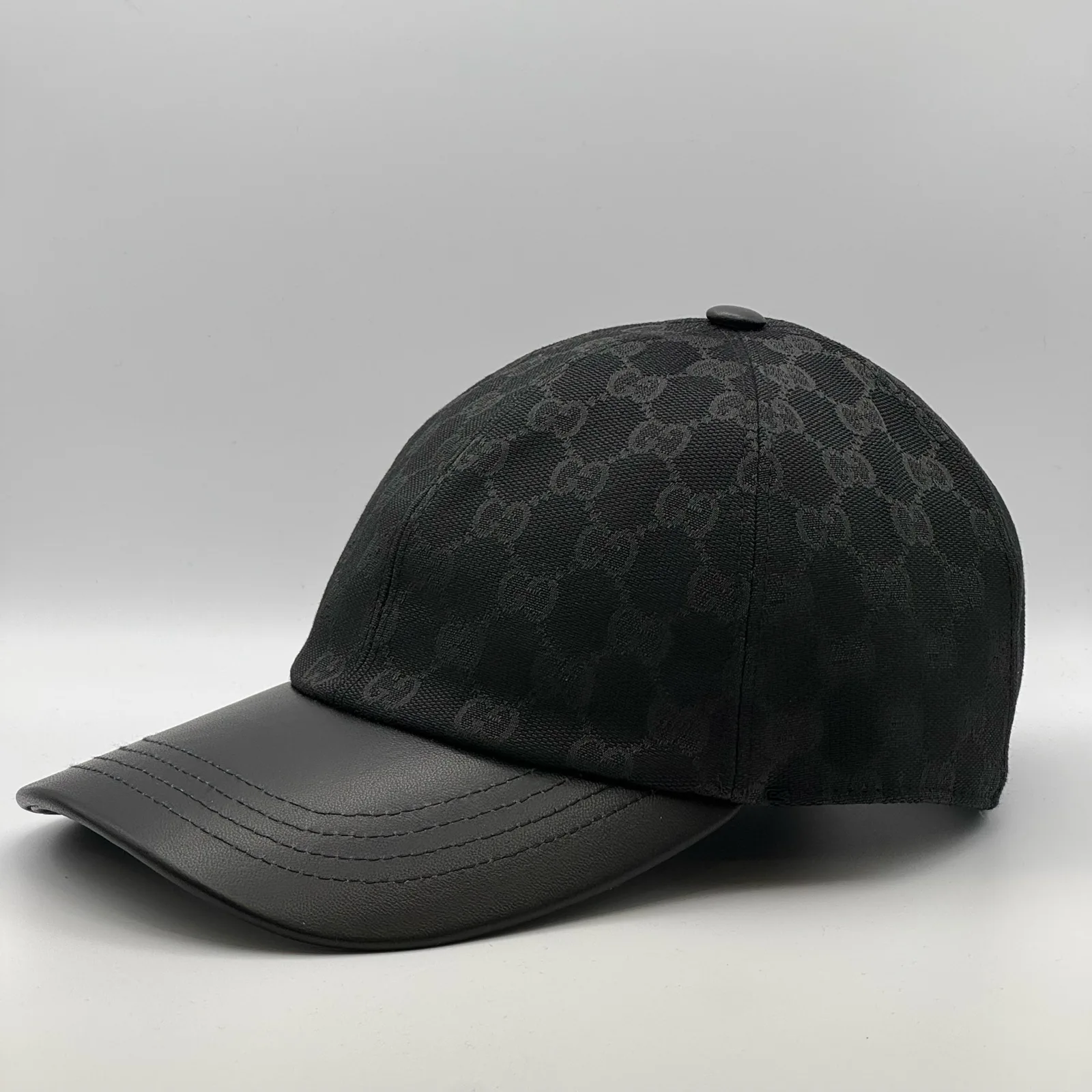 Black GG canvas cap, side view showing the black leather brim and strap