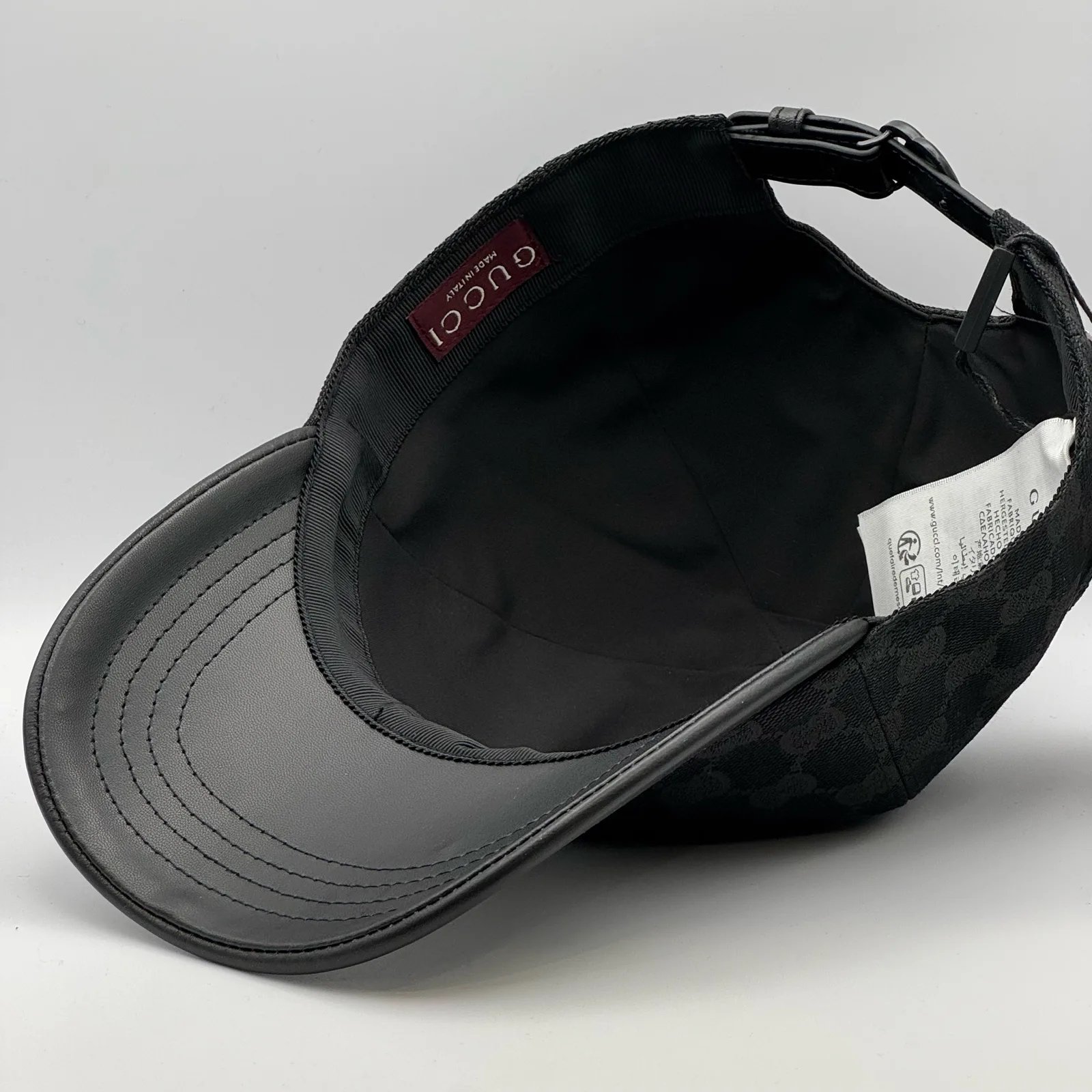 Black GG canvas cap, interior view showing the black lining and buckle strap