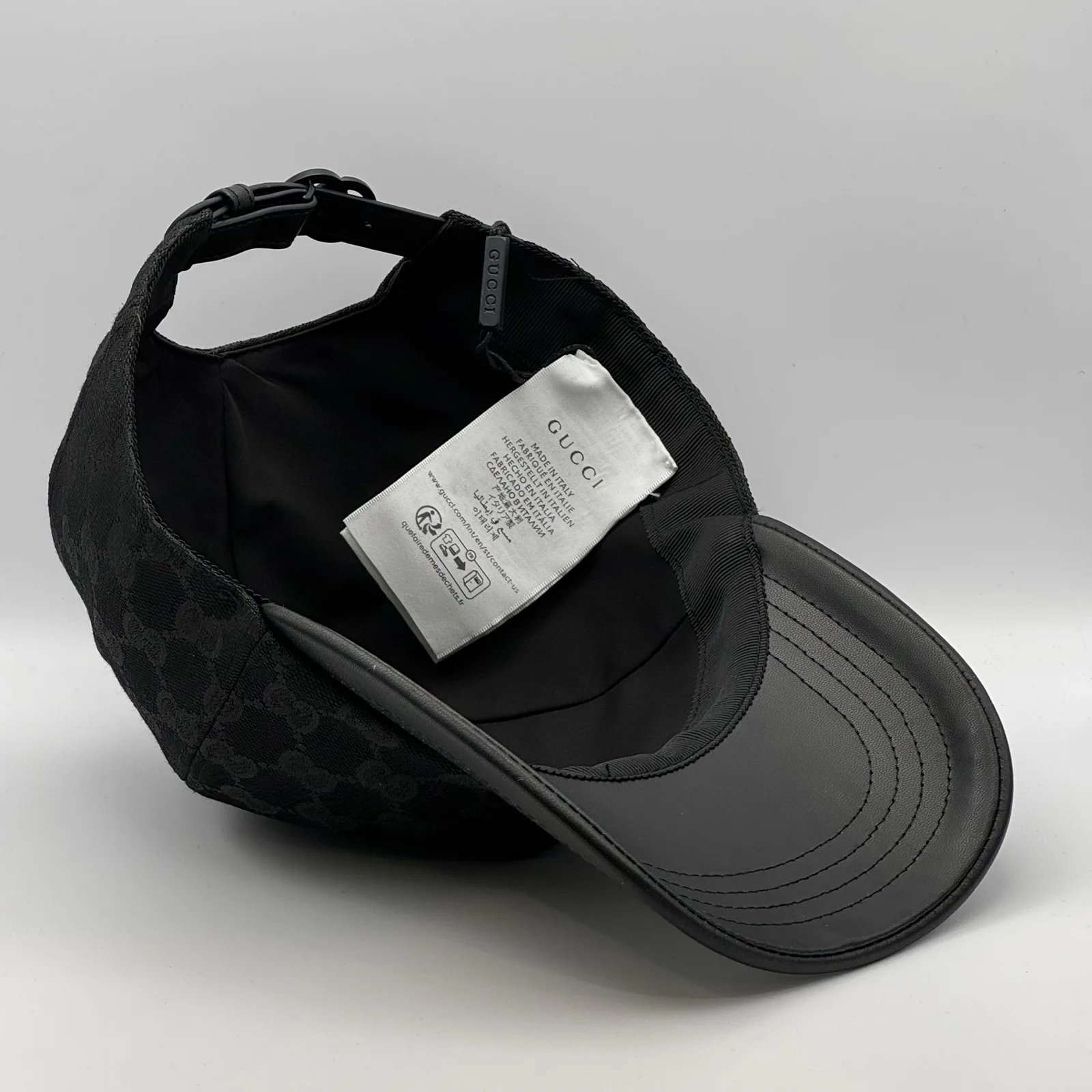 Black GG canvas cap, interior view showing the lining and hanging tag