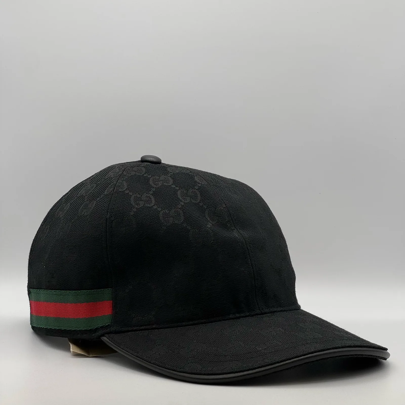 Black GG canvas cap, front three-quarter view with green and red web stripe trim