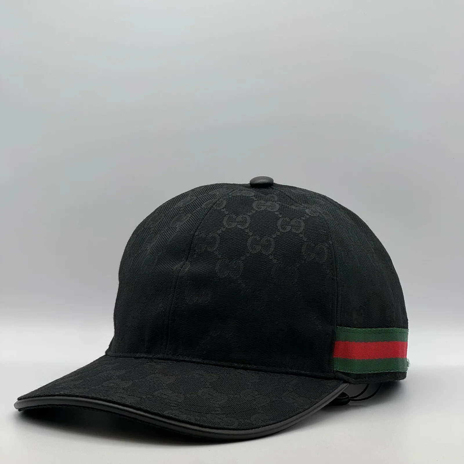 Black GG canvas cap, side view showing the green and red web stripe and leather brim