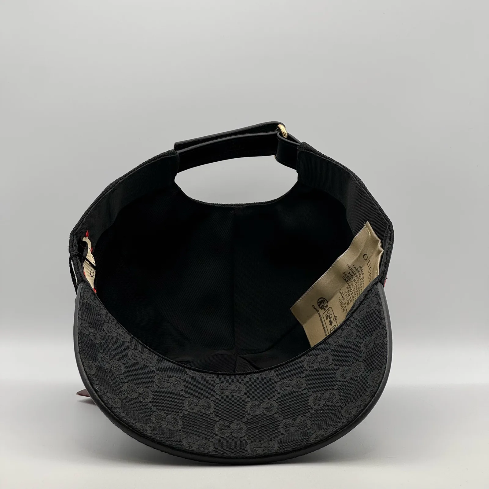 Black GG canvas cap, underside view showing the interior lining and brand tag