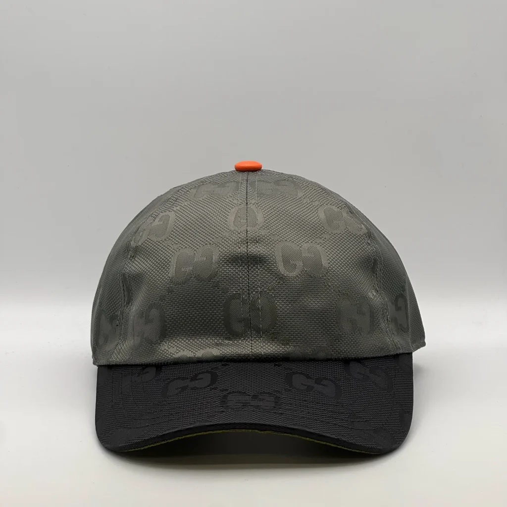 Grey GG jacquard cap with black brim and orange top button, front view