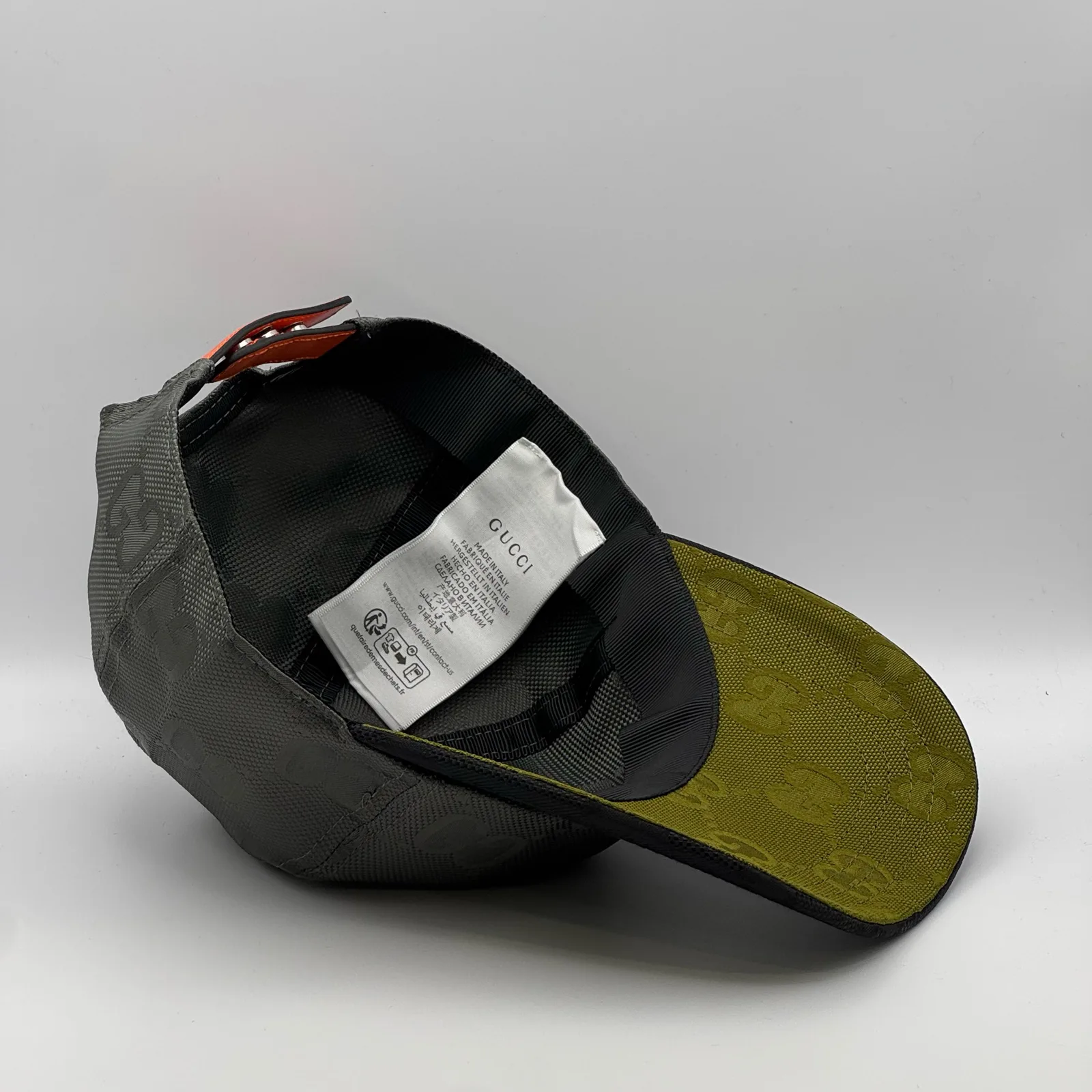 Grey GG cap interior, care label and orange strap buckle
