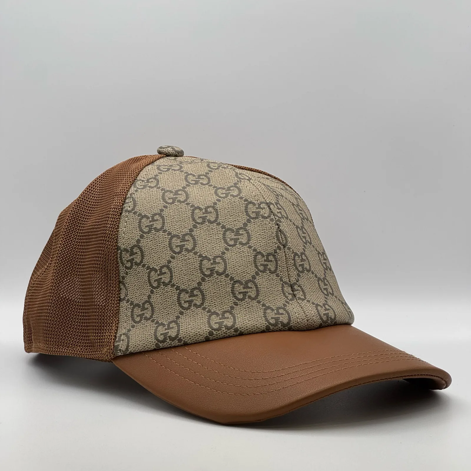 Brown GG trucker cap, three-quarter view showing mesh back panel