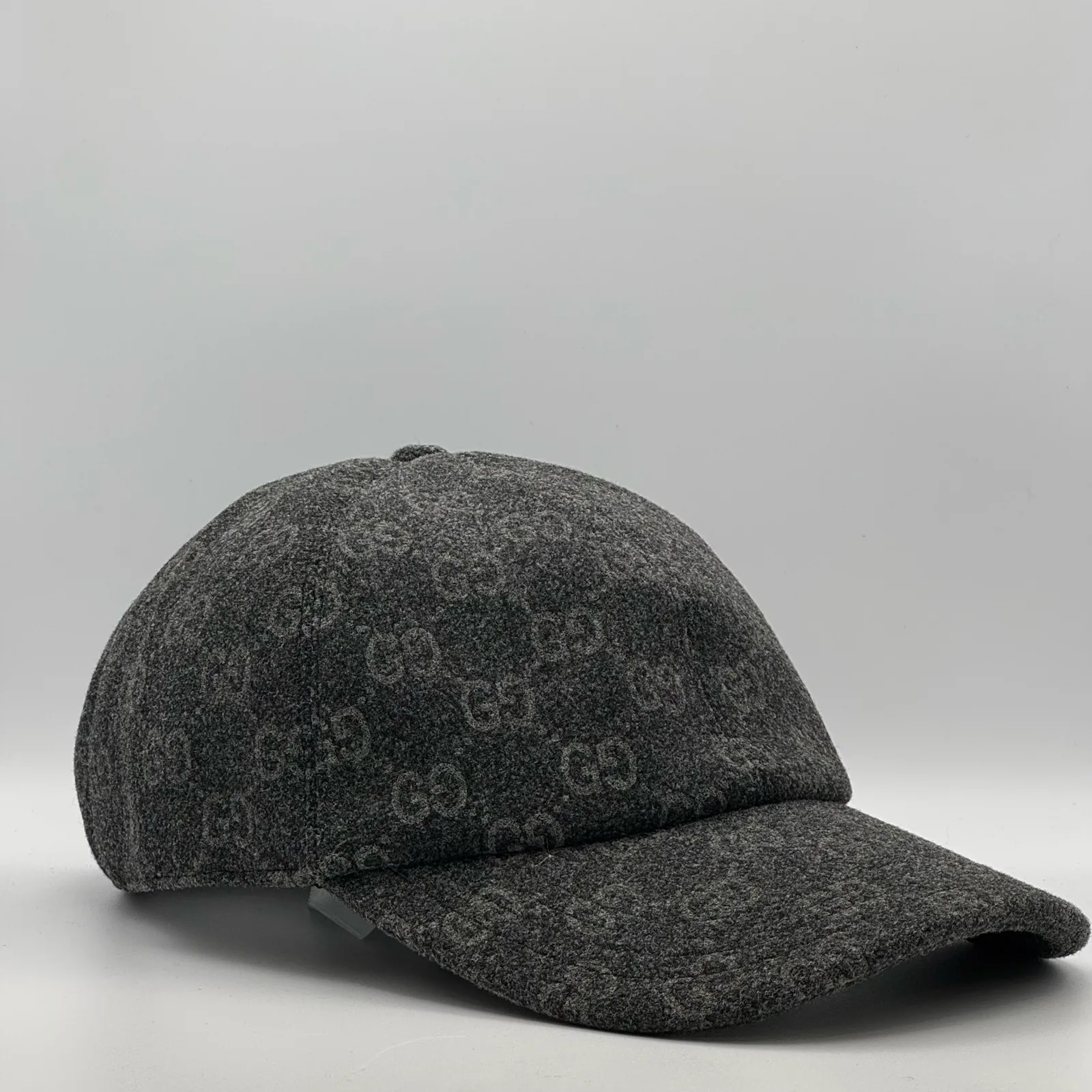 Charcoal GG wool cap, three-quarter view showing curved brim and crown