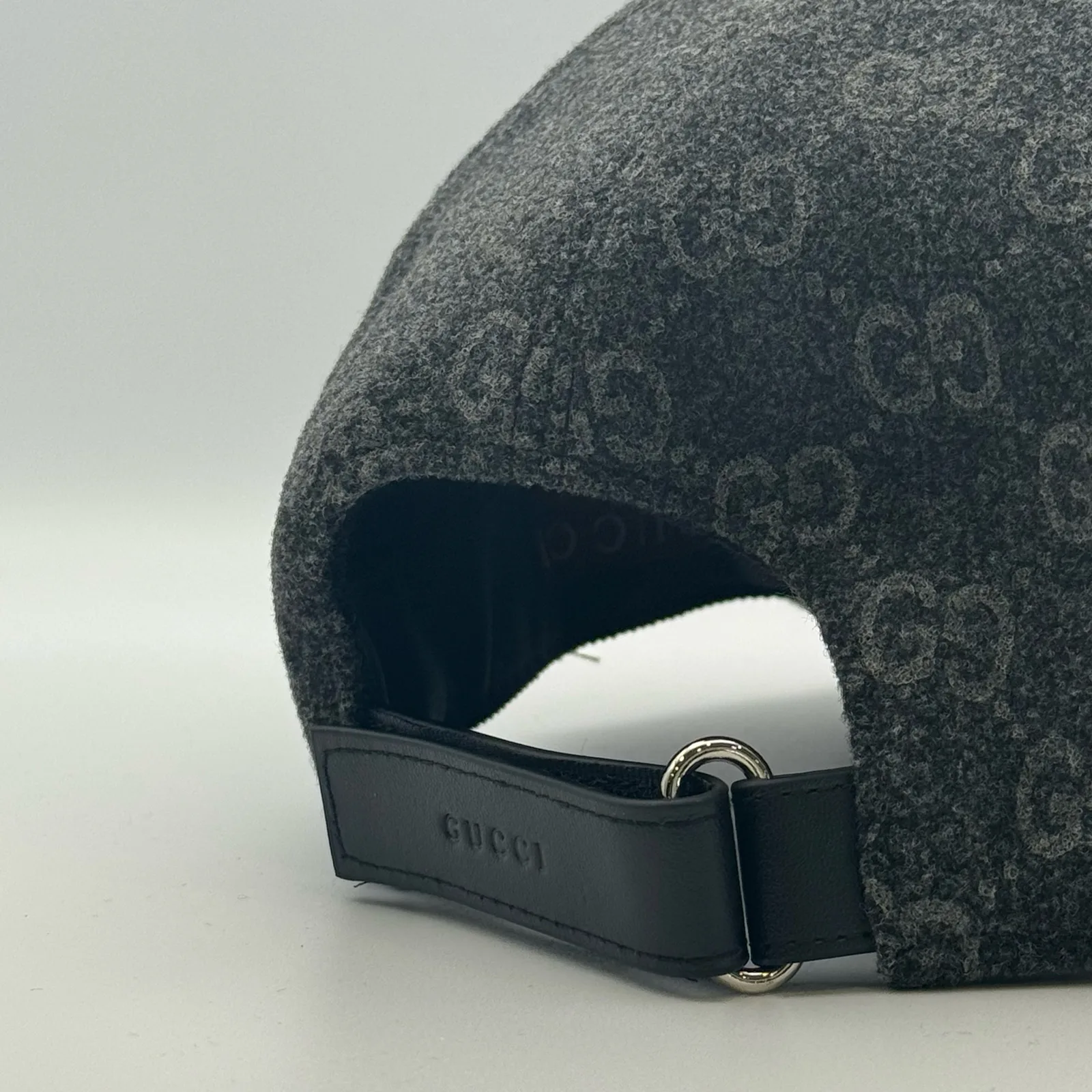 Close-up of leather strap closure with buckle and Gucci embossing