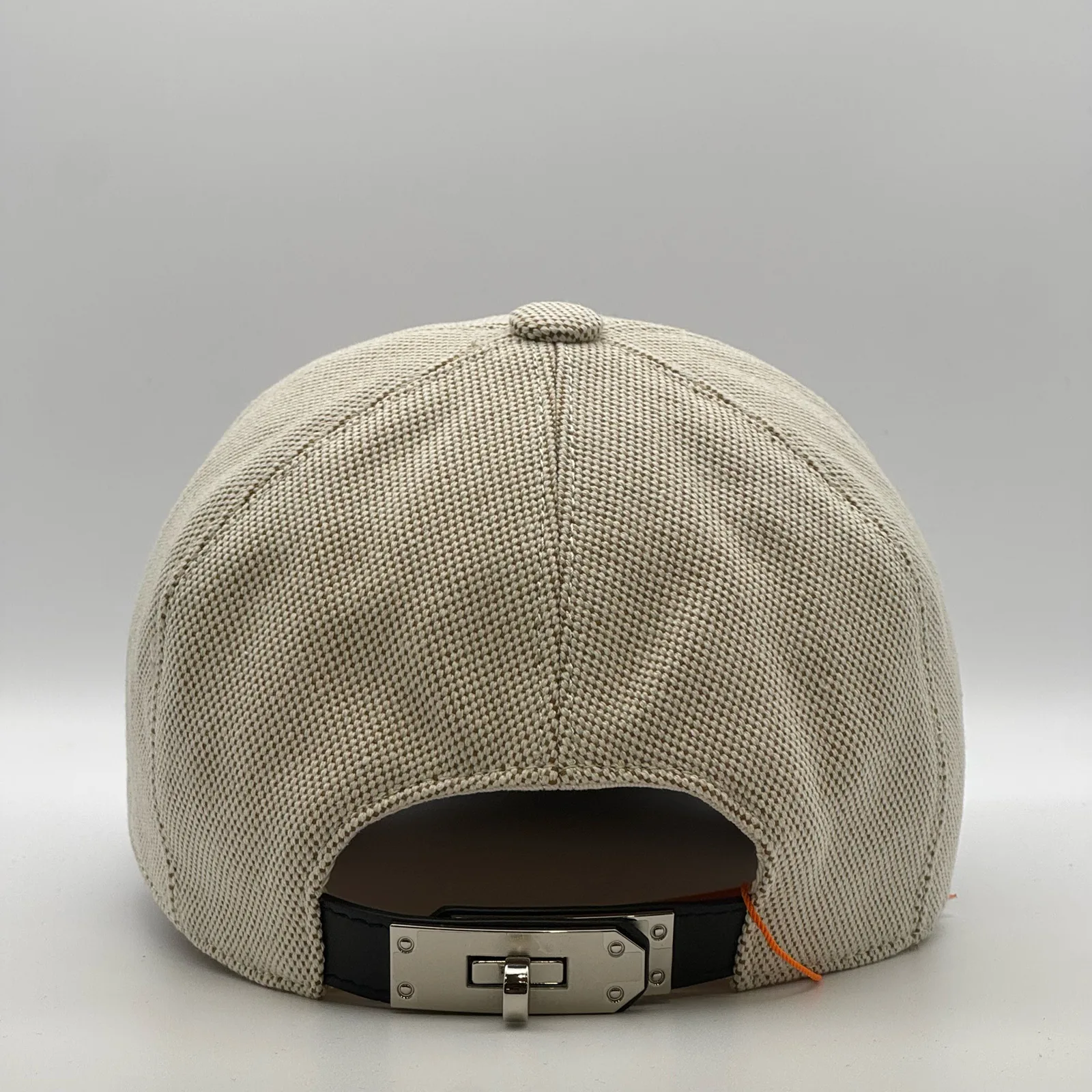 Hermès canvas cap, back view showing the black leather strap and metal buckle closure.
