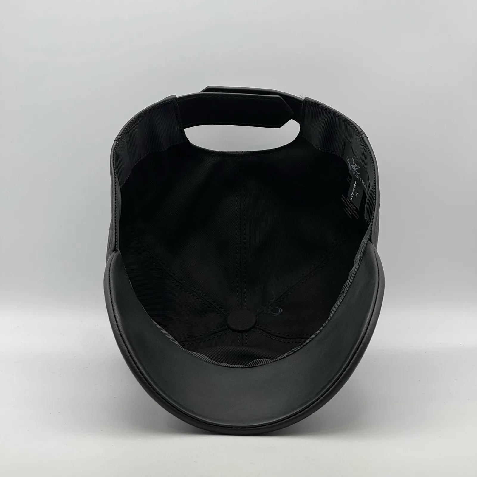 Inside view of the black leather cap showing the open crown.