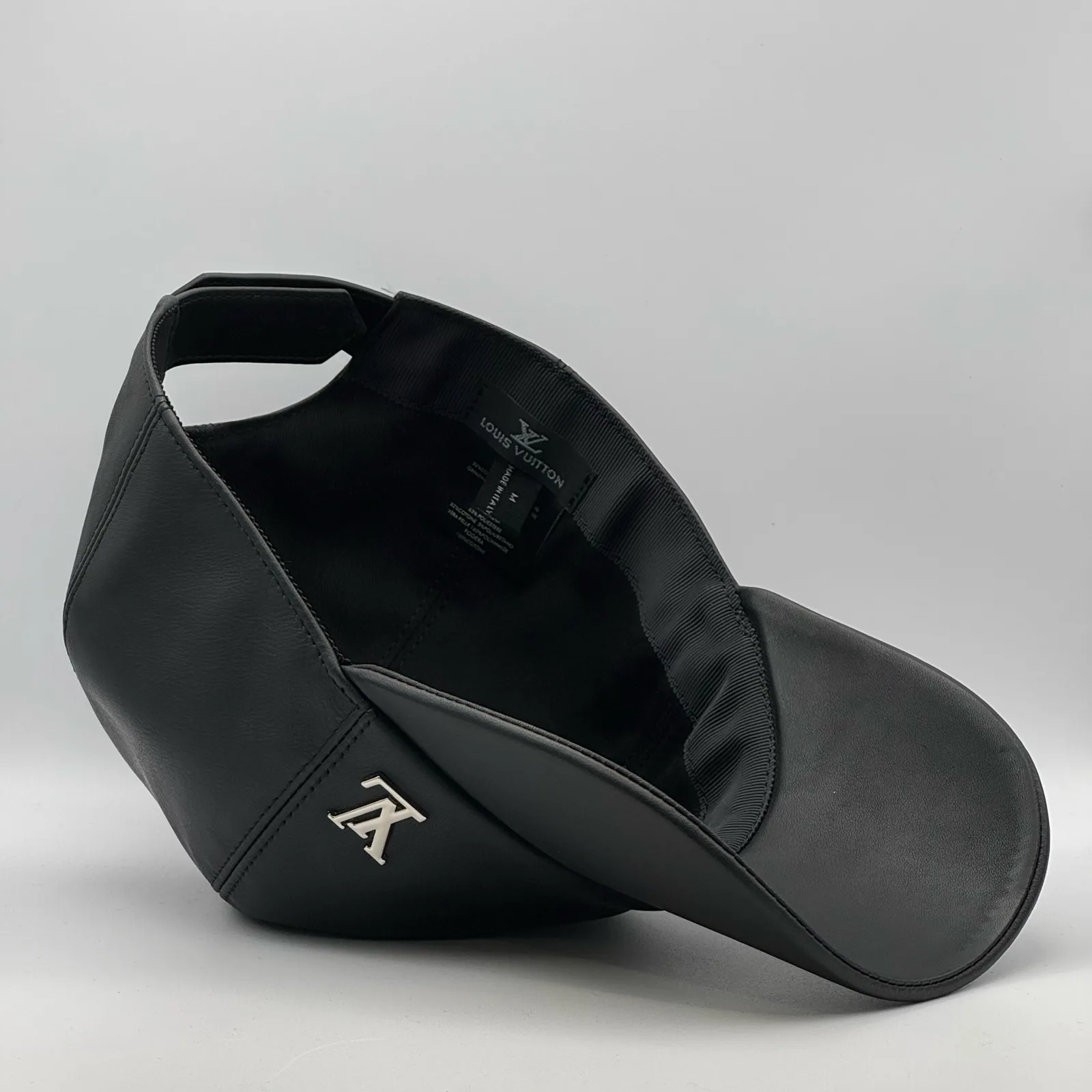 Angled inside view of the black leather cap and brim.