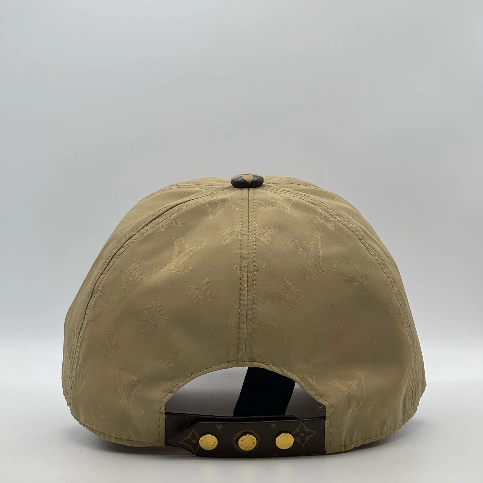 Beige monogram brim cap, back view showing the gold snap-stud closure.