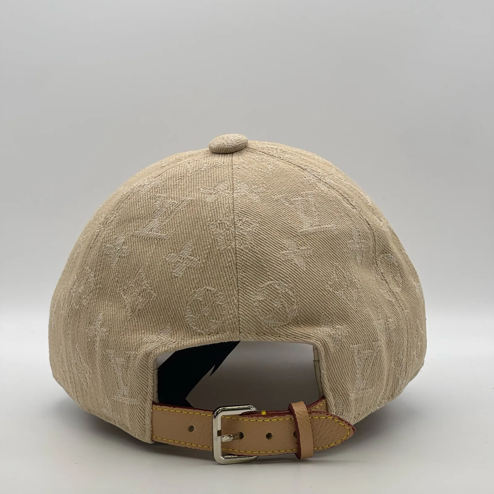 Beige monogram cap, back view showing the tan leather strap.