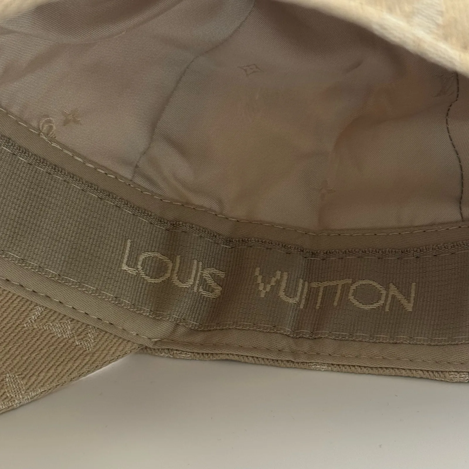 Close-up of the Louis Vuitton lettering along the brim edge.