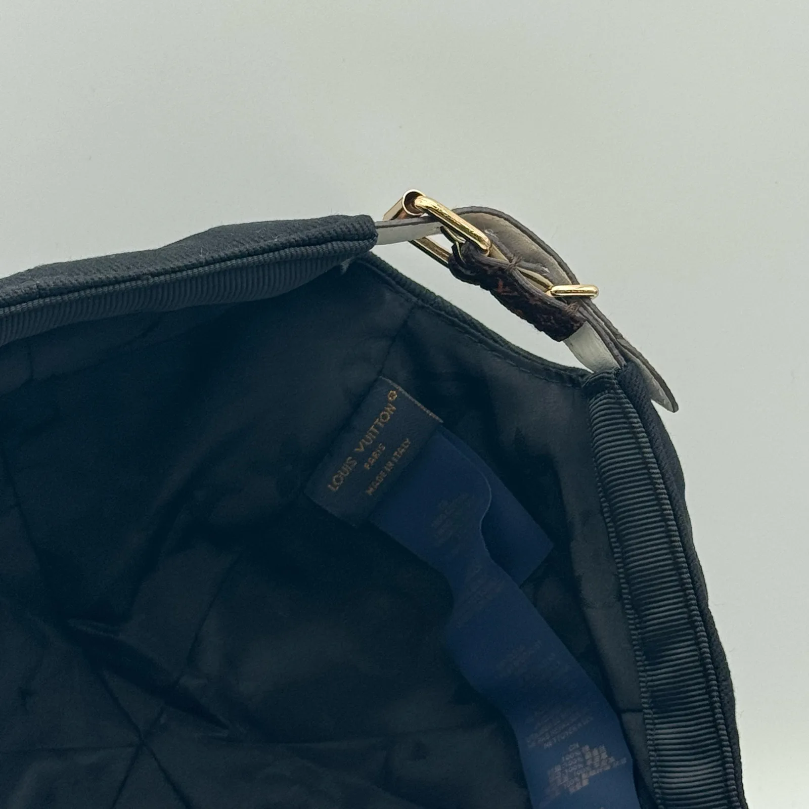 Close-up of the leather strap and buckle on the black flower cap.