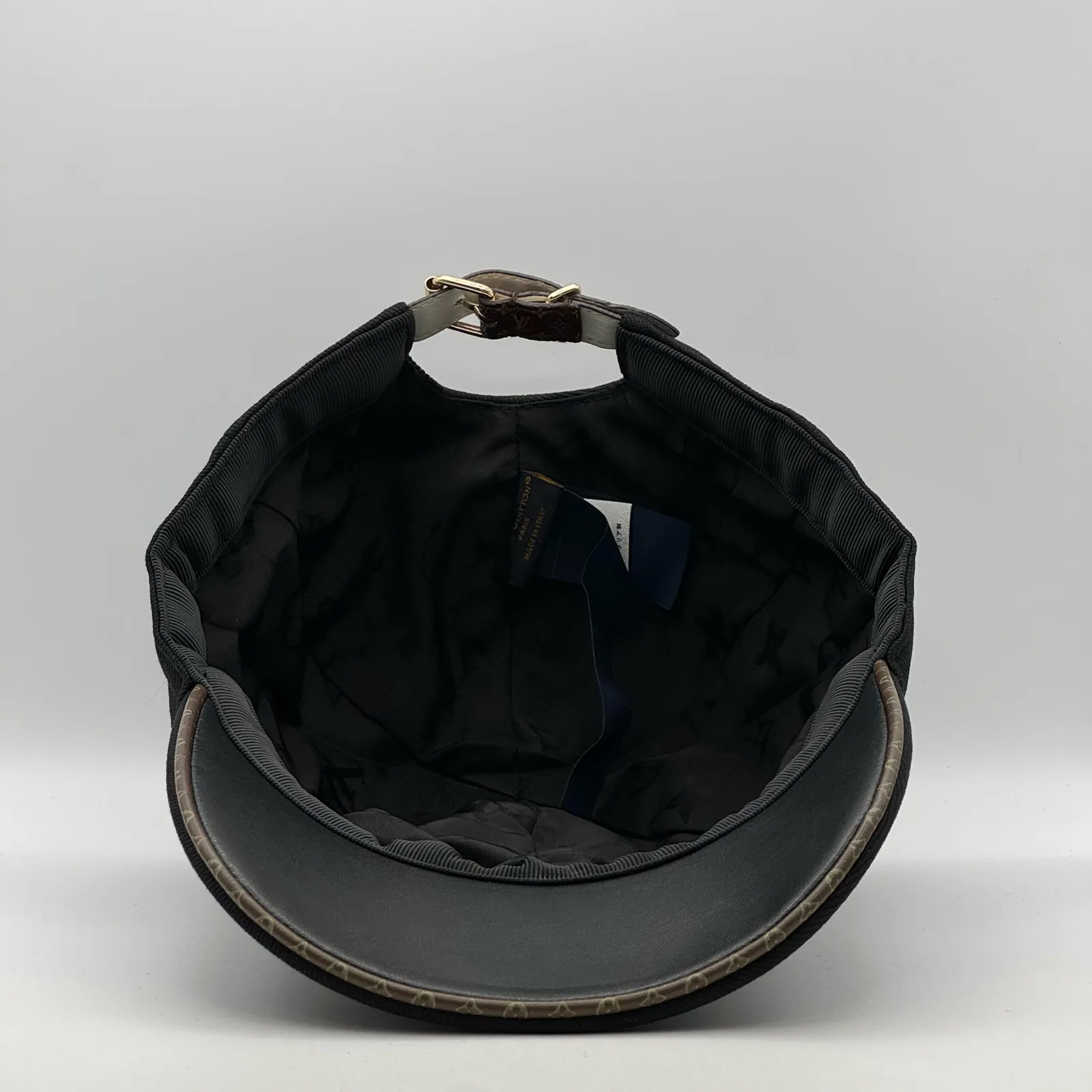 Inside view of the black flower cap showing the lining and strap.