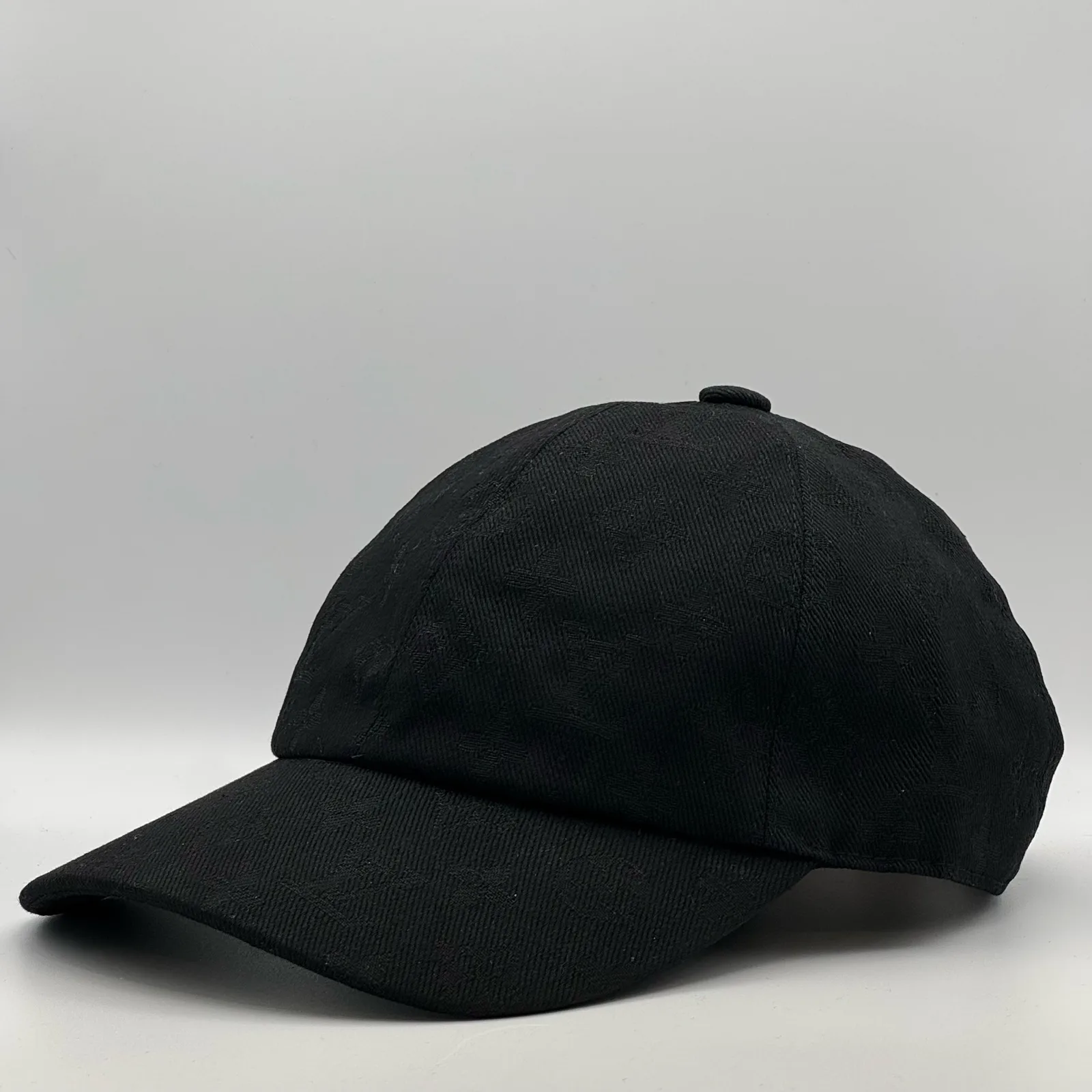 Black monogram jacquard cap, side profile view.