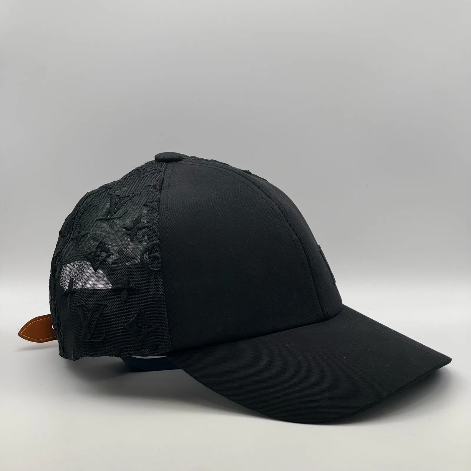 Black monogram mesh cap, three-quarter side view showing the mesh panel.