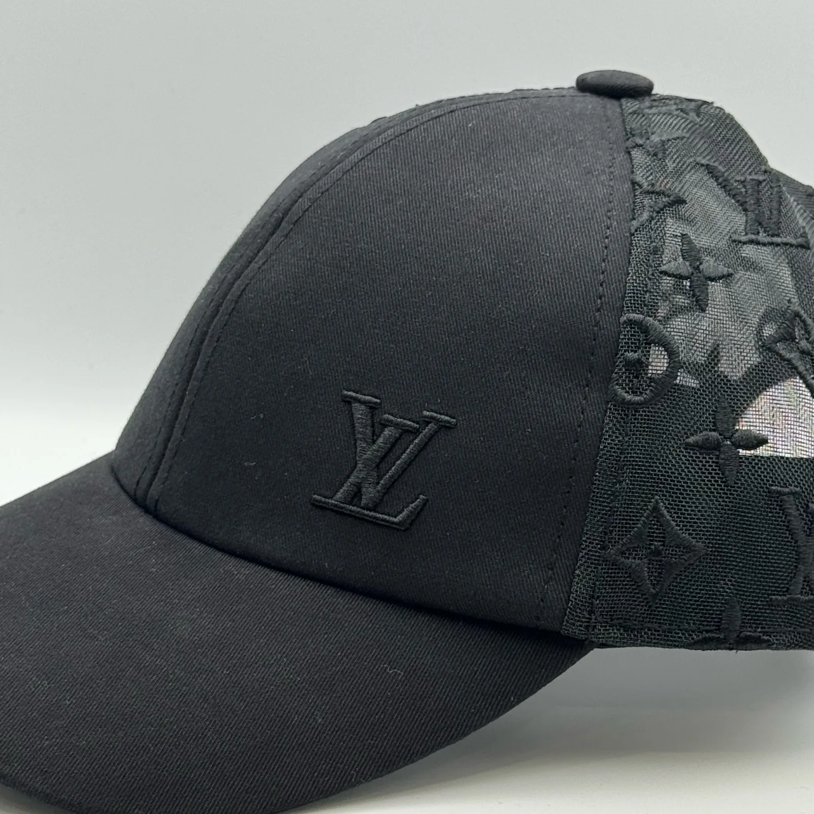 Close-up of the LV logo and monogram mesh side panel.