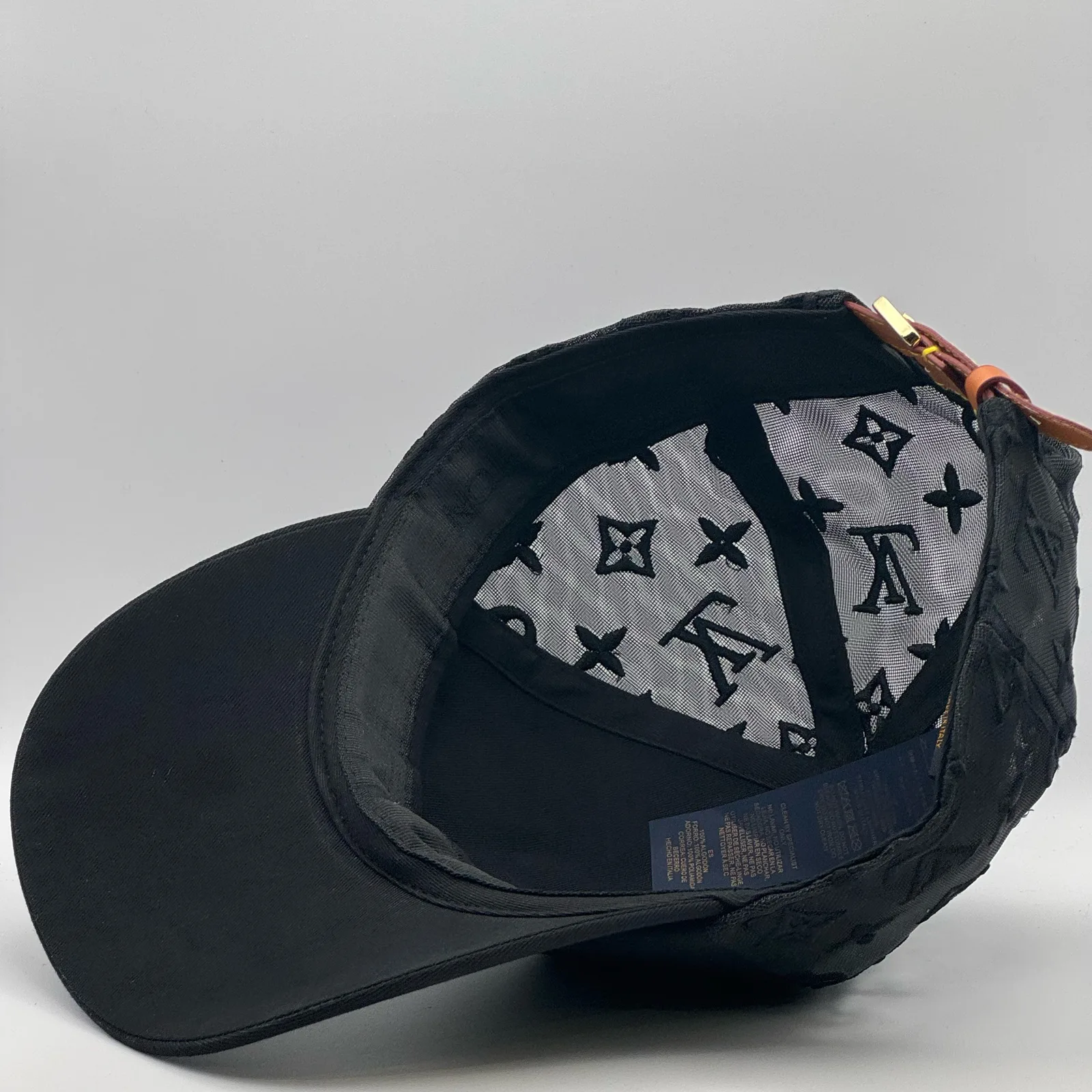 Angled inside view of the black monogram mesh cap and strap.